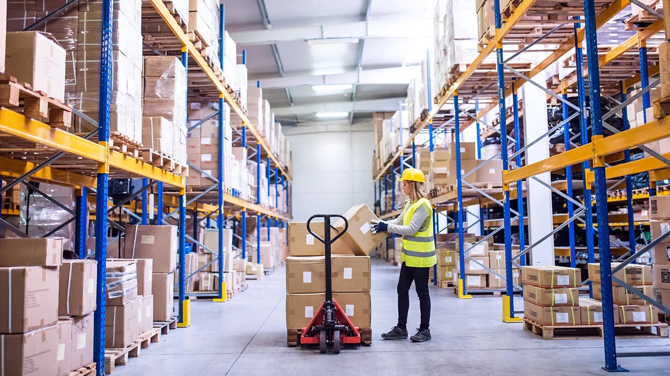 Warehouse worker preparing packages for order fulfillment in a large storage facility